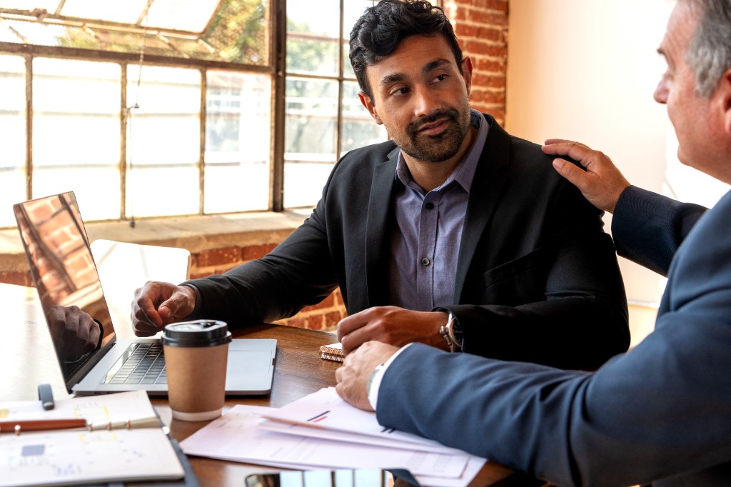 A business banker meeting with a client at a desk in a bright office