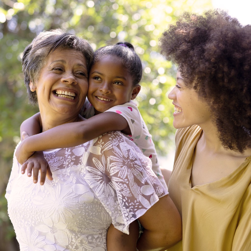 Grandmother smiling with two grandchildren outdoors