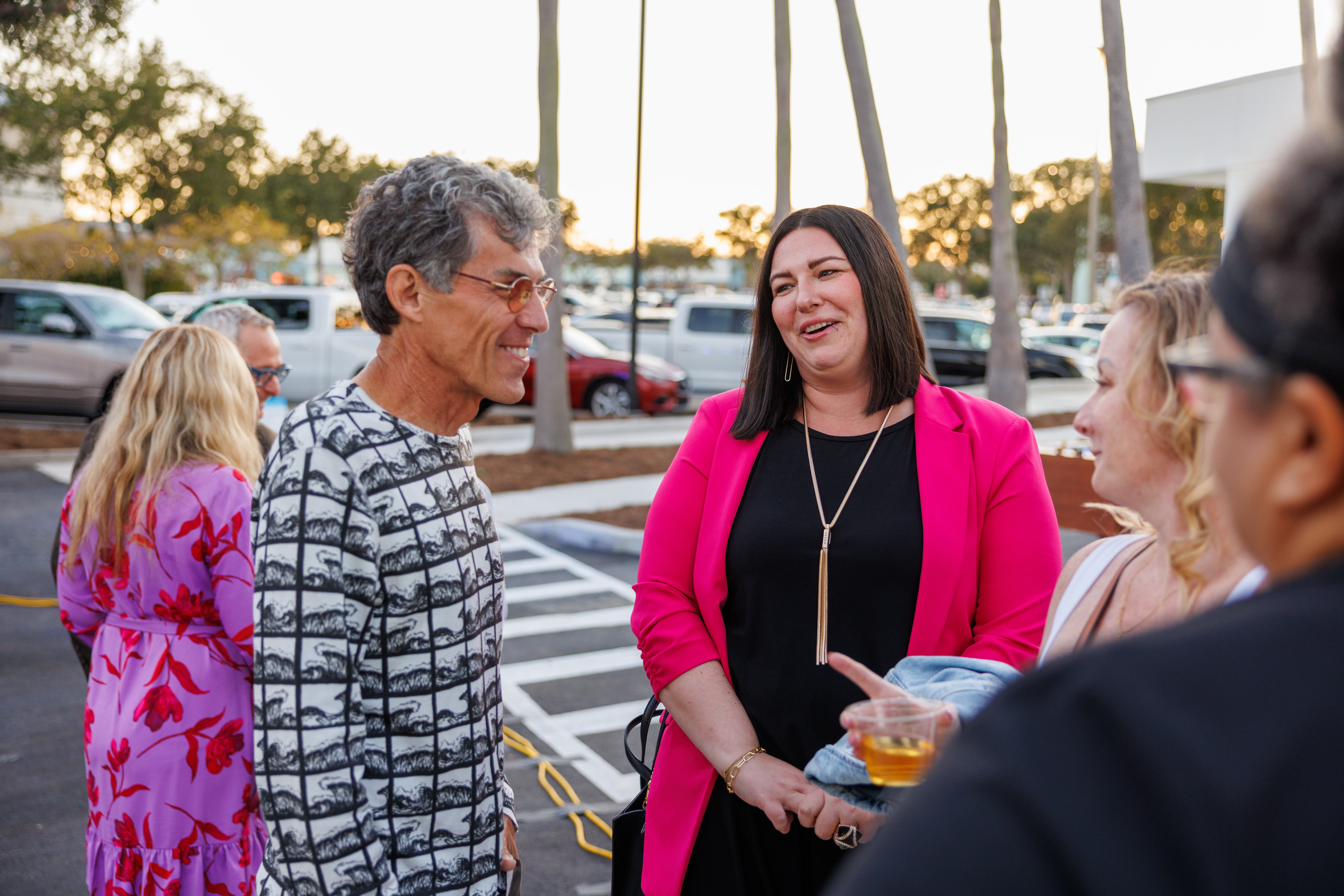 Group of adults talking outdoors in a parking lot. Climate First Bank's CEO, Ken LaRoe, is pictured. 