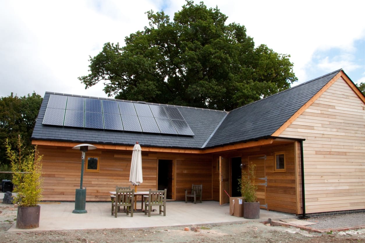 Wooden barn with solar panels on the roof.
